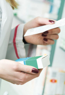 Closeup Hand Of Woman Pharmacist With Prescription And Medicine At Drugstore