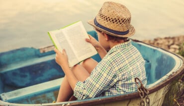Boy Reading On The Beach