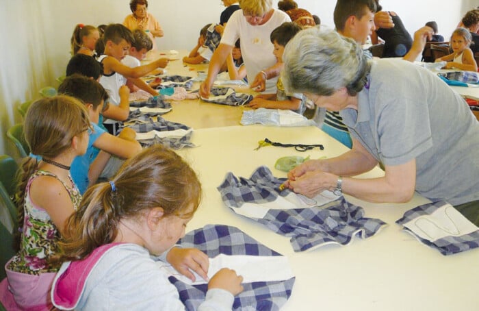 un laboratorio di cucito organizzato da volontarie Auser con bambine del territorio