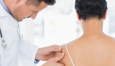 Doctor Examining Melanoma On Woman