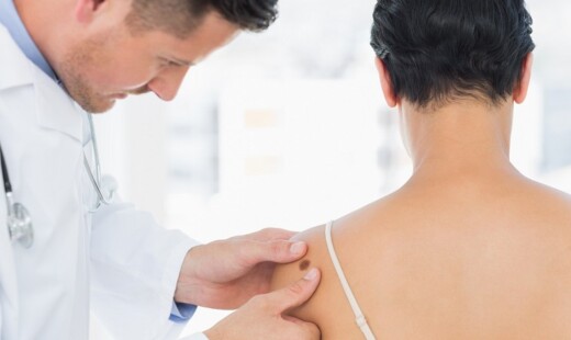 Doctor Examining Melanoma On Woman