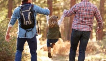 Gay Male Couple With Daughter Walking Through Fall Woodland