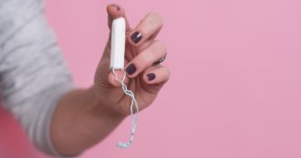 Woman's Hand Holding A Clean Cotton Tampon