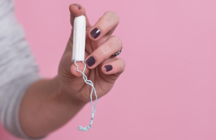 Woman's Hand Holding A Clean Cotton Tampon