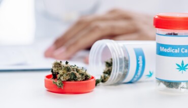 Selective Focus Of Bottle With Medical Cannabis On White Table