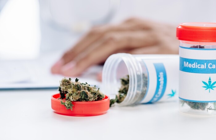 Selective Focus Of Bottle With Medical Cannabis On White Table