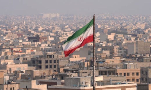 The City Of Tehran With The Waving Iranian Flag In The Foreground