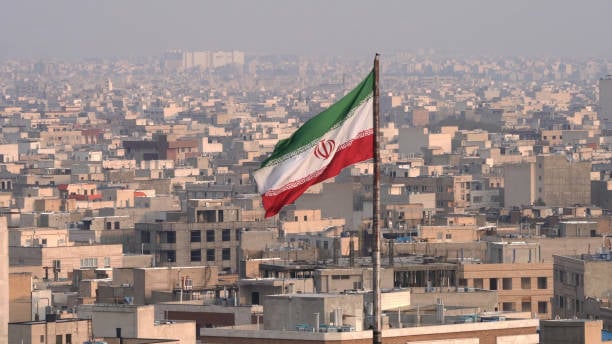 The City Of Tehran With The Waving Iranian Flag In The Foreground